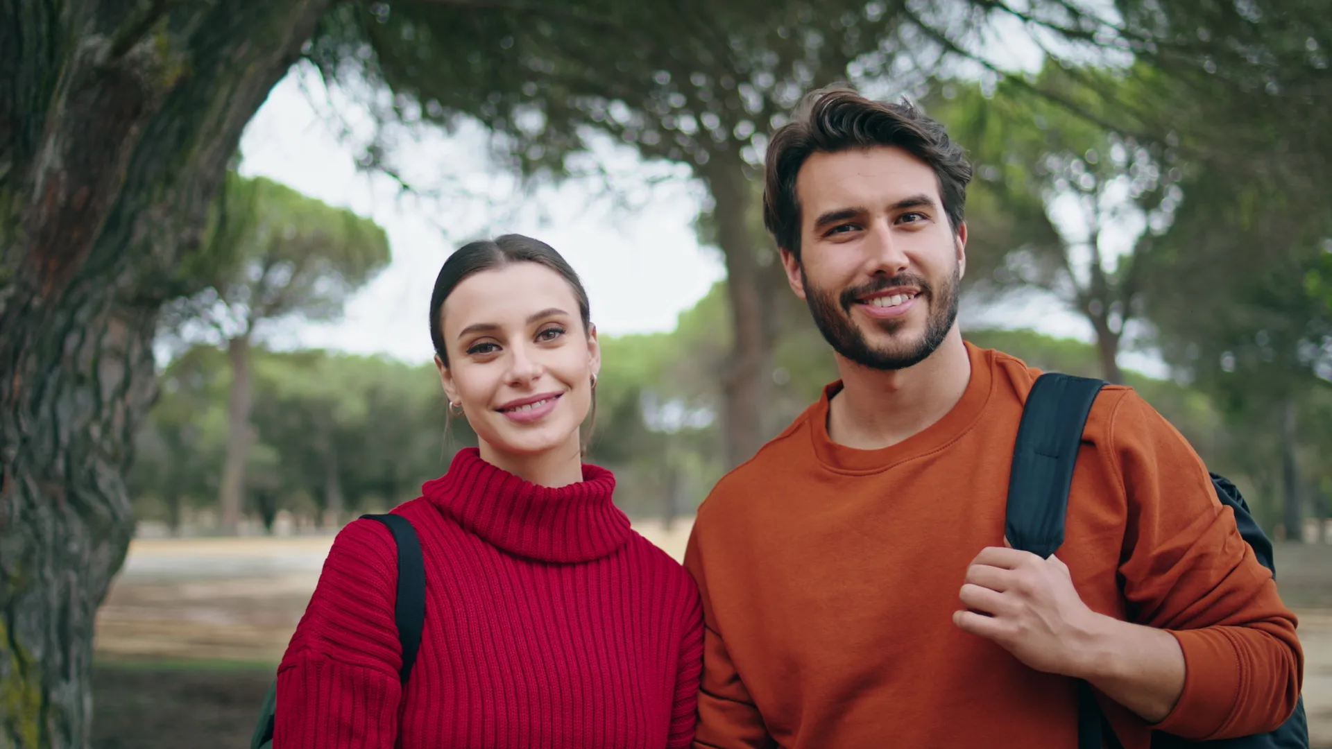 two hikers smiling standing autumn forest closeup utc