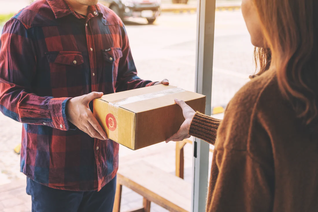 woman receiving parcel box from delivery man at th utc